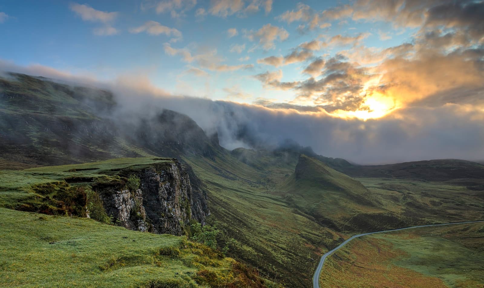 Soft light breaking over calm, rolling hills